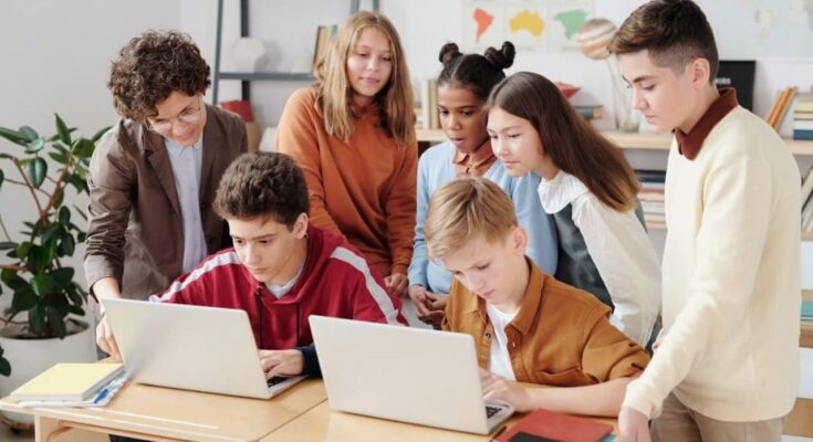 Élèves devant ordinateurs dans une salle de classe