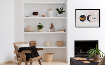 Salon moderne à la décoration épurée avec une étagère murale d'objets artisanaux, un fauteuil en rotin et un cadre décoratif
